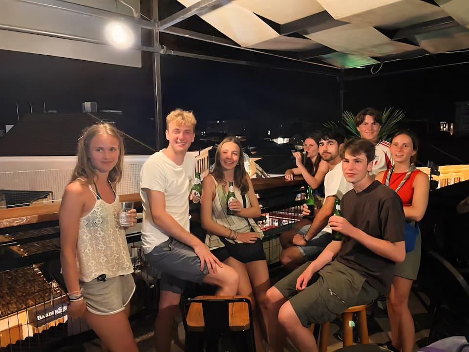 Guests relaxing on the Scodrinon Hostel rooftop at sunset