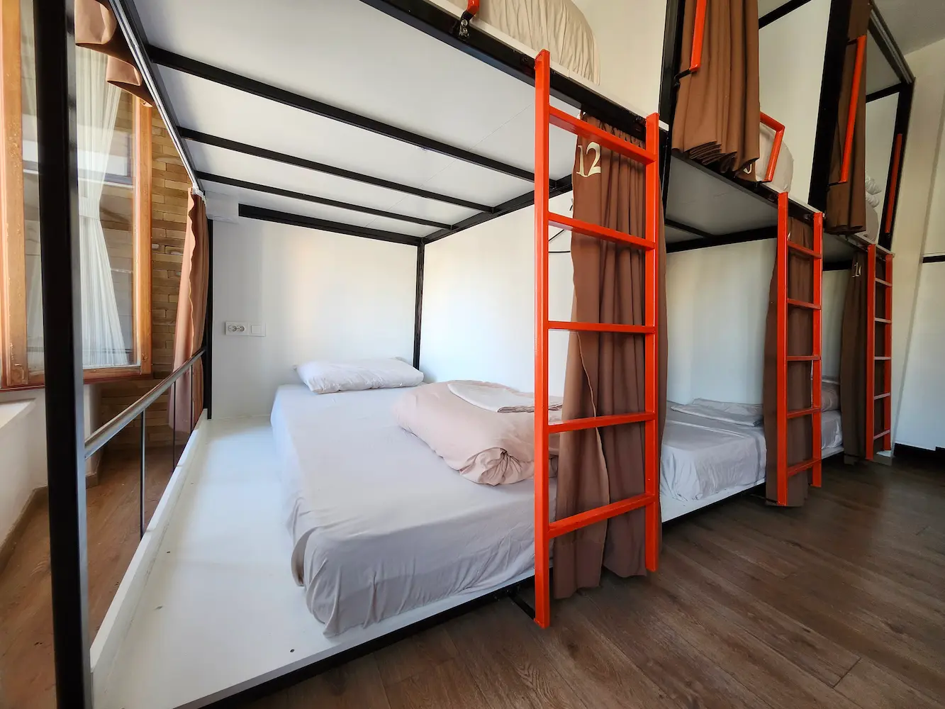 Privacy pods and dorm layout at Scodrinon Hostel 18-bed room
